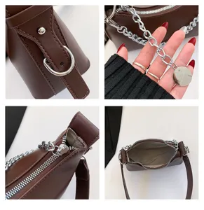 Detailed view of women brown underarm shoulder bag with silver chain and metal zipper.