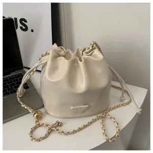 Cream bucket bag detail, soft PU leather surface, elegant gold chain strap and drawstring.