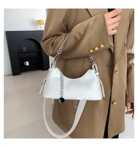 Detailed view of trendy white underarm bag featuring a stylish silver chain and leather strap.