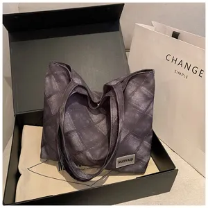 Detailed view of dark grey quilted tote bag in gift box, showing large capacity and handles.