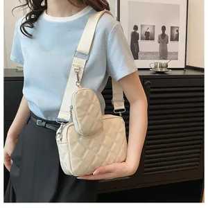 Detailed shot of a chic beige quilted crossbody bag with a handy strap pouch and wide strap.