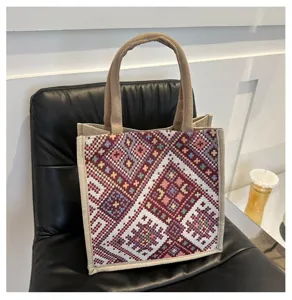 Ethnic style canvas tote bag detail, colorful geometric woven pattern and jute handle.