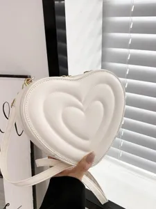 Close-up detail of white heart crossbody bag PU leather quilted texture fashion accessory
