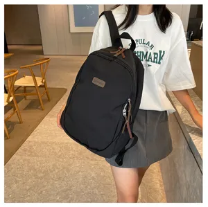Classic black canvas backpack for students, casual daily travel daypack with zipper and pockets.