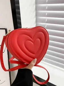 Red heart shaped crossbody shoulder bag detail showing quilted texture and metal chain.