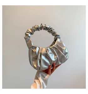 Close up of the stylish pleated silver cloud handbag, showing the soft gathered handle detail.