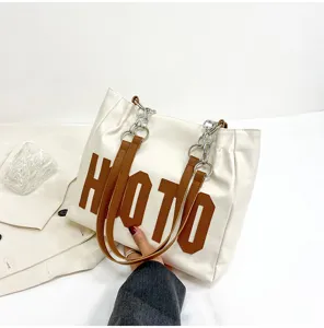 White canvas tote bag with brown straps and letters, daily shoulder bag for women.