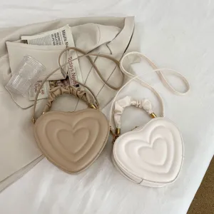 Chic quilted heart-shaped crossbody bag with gathered handle and stylish retro design for women.
