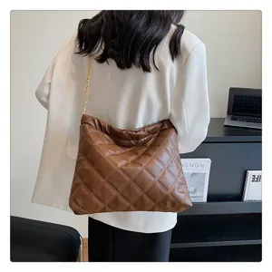 Detailed view of the women brown quilted shoulder bag featuring soft leather and chain strap.