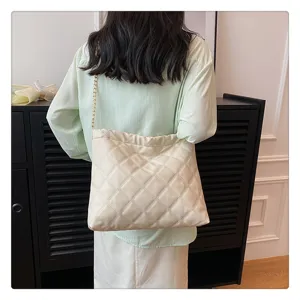Quilted shoulder bag detail showcasing soft leather texture, chic gold chain strap, and elegant style.