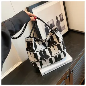 Detail shot of the black and white knitted rabbit pattern tote bag handle and fabric texture.