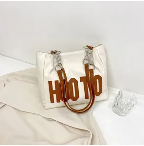 Detail view of women's PU leather tote bag with brown letter print and chain straps.