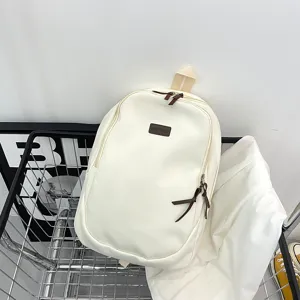 Close-up detail of a minimalist solid color canvas backpack displayed neatly in a wire basket.