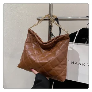 Detailed view of brown quilted hobo shoulder bag with chain strap and soft leather material.
