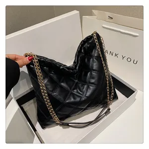 Detailed shot of a black quilted shoulder bag with gold chain strap, stylish design.