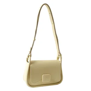 Gros plan sur le détail de la sangle du sac à bandoulière crème, design minimaliste chic.