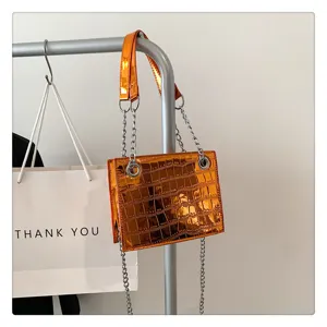 Close-up detail of the orange metallic laser texture chain shoulder bag with metal hardware.