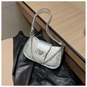 Silver metallic crocodile texture shoulder bag detail shot with heart metal clasp and chain.