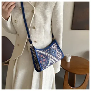 Close-up detail of the blue geometric woven shoulder underarm bag with sleek leather trim.