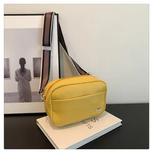 Detailed view of the stylish yellow PU leather crossbody bag featuring a chic wide strap.
