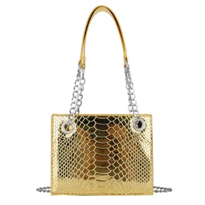 Détail de sac à main doré effet croco, mettant en valeur sa texture brillante et sa chaîne.