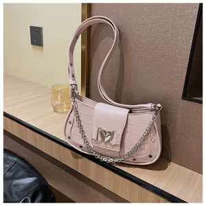 Close-up view of a pink stylish baguette shoulder bag with a chic heart buckle and chain.