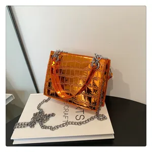 Close-up view of the orange metallic crocodile pattern chain handbag displaying fine texture.