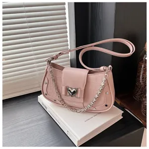 Pink crocodile texture shoulder bag detail, featuring metal heart buckle and chain accent.