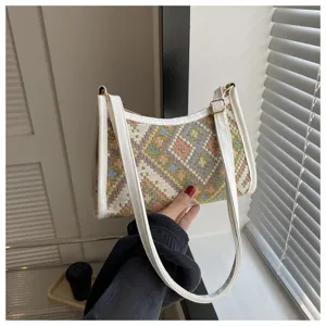 Detailed shot of ethnic woven underarm bag with white PU leather trim and chic shoulder strap.