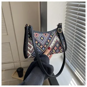 Close-up detail shot of the ethnic geometric pattern shoulder underarm bag with black leather trim.