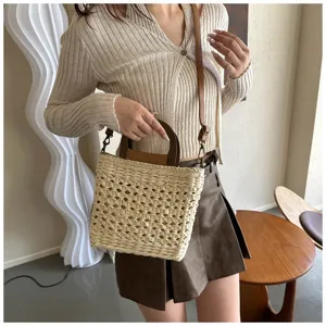 Woven straw bucket bag for women, stylish top handle handbag with shoulder strap, casual design.