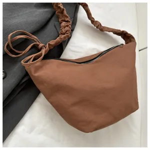 Casual brown canvas crossbody shoulder bag with stylish pleated strap and secure zipper closure.