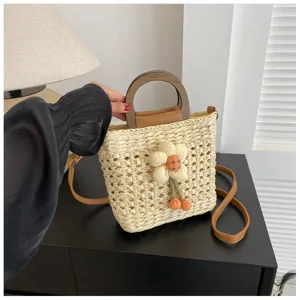 Detailed view of women's straw woven bucket bag with wooden handle and floral decor.