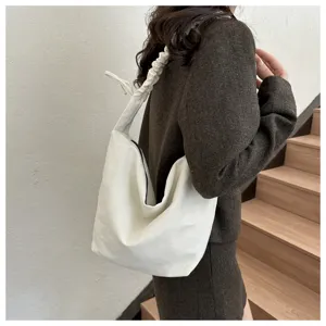 Detail view of the casual white canvas shoulder bag featuring a stylish gathered strap design.