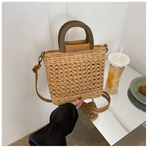 Woven straw bucket bag with wooden handle and crossbody strap, stylish casual summer handbag.