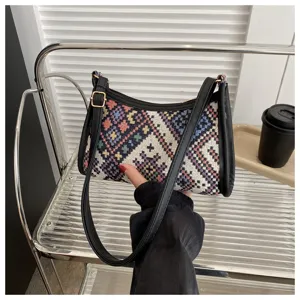 Ethnic woven underarm bag featuring geometric pattern, black leather trim and metal hardware.