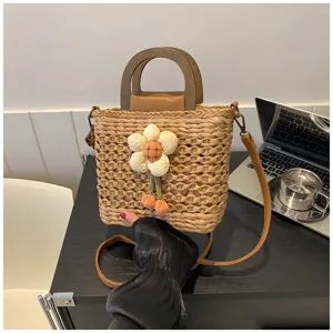 Detail shot of a stylish straw bucket bag with wooden handle and cute floral decor.