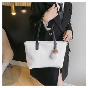 White plush shoulder bag for women, cozy winter fluffy handbag with black handles and cute charm.