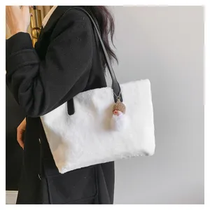 White plush shoulder bag detail showing soft lambswool texture and black strap design.
