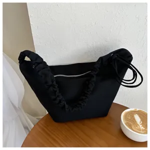Black canvas hobo shoulder bag with stylish gathered strap design for casual daily use.