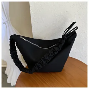 Black canvas hobo shoulder bag detail, featuring ruched strap and silver metal zipper design.
