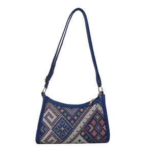 Detailed view of the ethnic geometric woven shoulder bag, showing fine texture and blue trim.