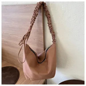 Minimalist brown canvas crossbody bag with ruched strap, casual hobo tote for daily use.