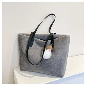 Grey fluffy faux fur tote bag close-up showing soft plush texture and black leather handles.