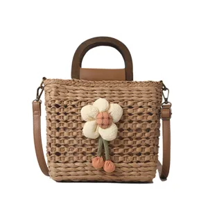 Stylish women woven straw bucket bag with wooden handle and cute fabric flower charm.