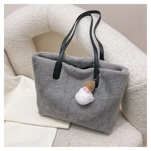 Elegant gray plush shoulder bag featuring black leather handles and a cute furry doll charm.