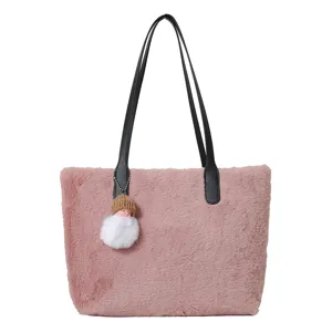 Close-up detail of the pink plush shoulder bag with black leather handles and cute doll keychain.