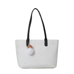 White fluffy shoulder bag for women, cozy winter lamb wool tote with black handles and cute charm.