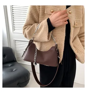 Brown underarm bag for women, stylish chain shoulder bag, fashion crossbody handbag detail view.