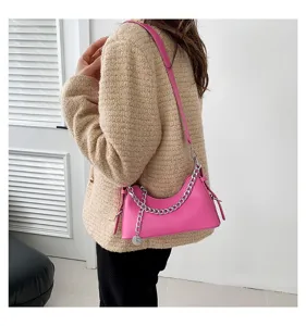 Detailed view of women pink fashion shoulder bag with silver chain strap, elegant style design.